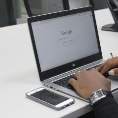 Man typing on laptop into Google search