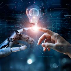 Human hand and robot hand reach to touch a shared lightbulb